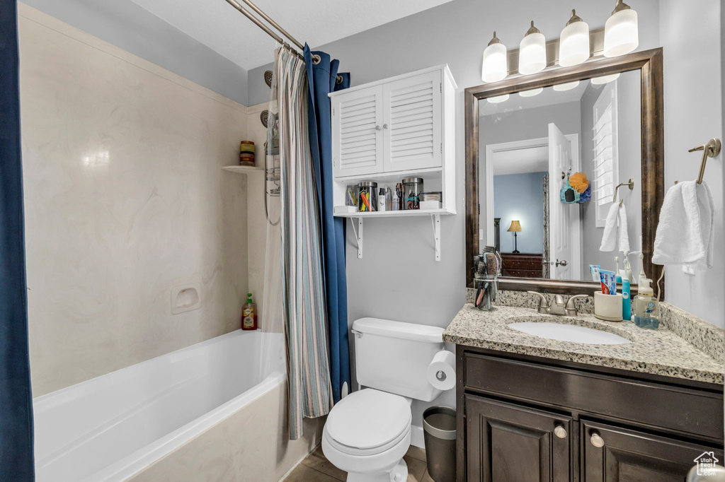 Full bathroom with tile floors, toilet, shower / bath combo, and oversized vanity
