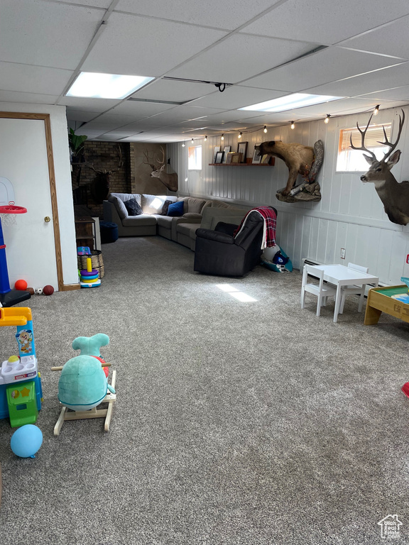 Rec room with plenty of natural light, a drop ceiling, and carpet