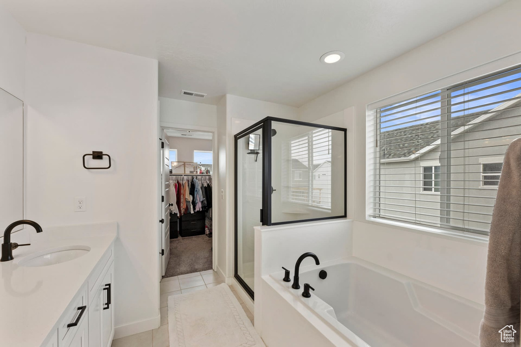 Bathroom featuring vanity, tile flooring, and separate shower and tub