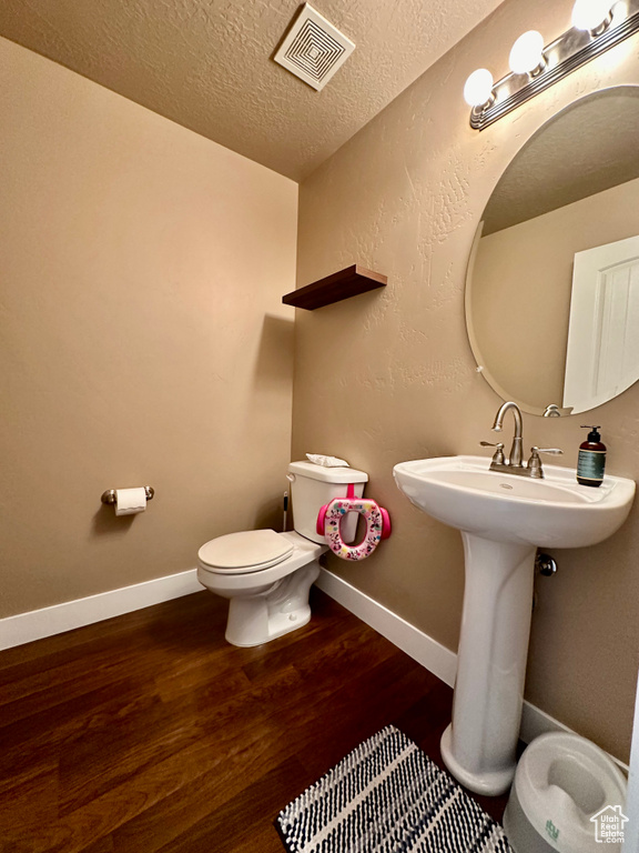 Bathroom featuring toilet, a textured ceiling, and hardwood / wood-style floors