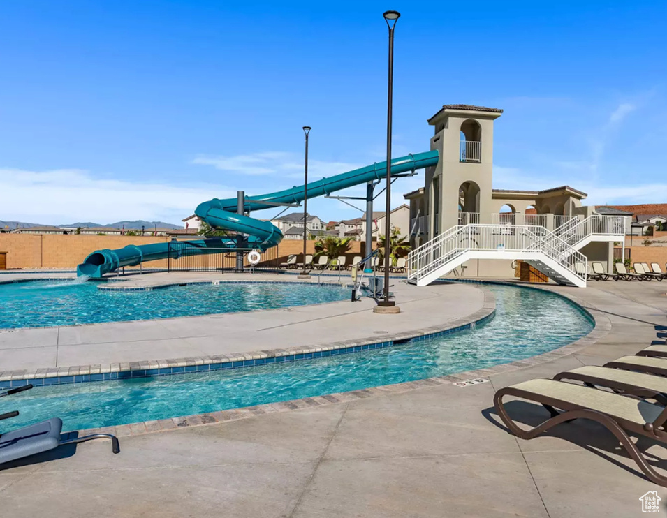 View of swimming pool with a patio, a jacuzzi, and a water slide
