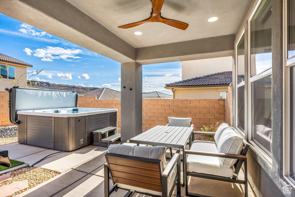 View of terrace featuring a hot tub and ceiling fan