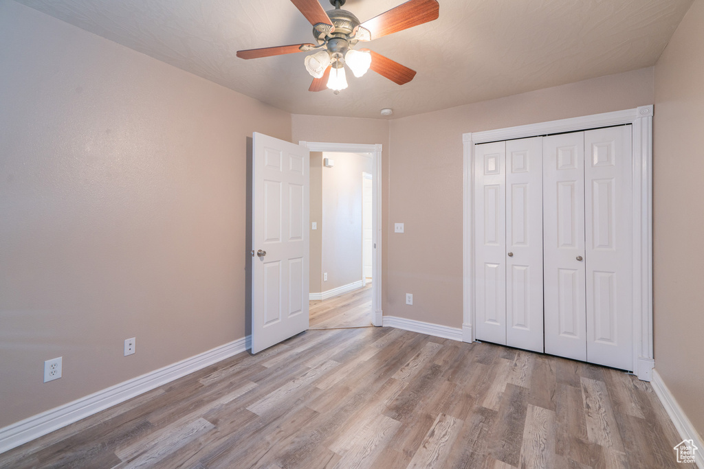 Unfurnished bedroom featuring ceiling fan, a closet, and light hardwood / wood-style floors