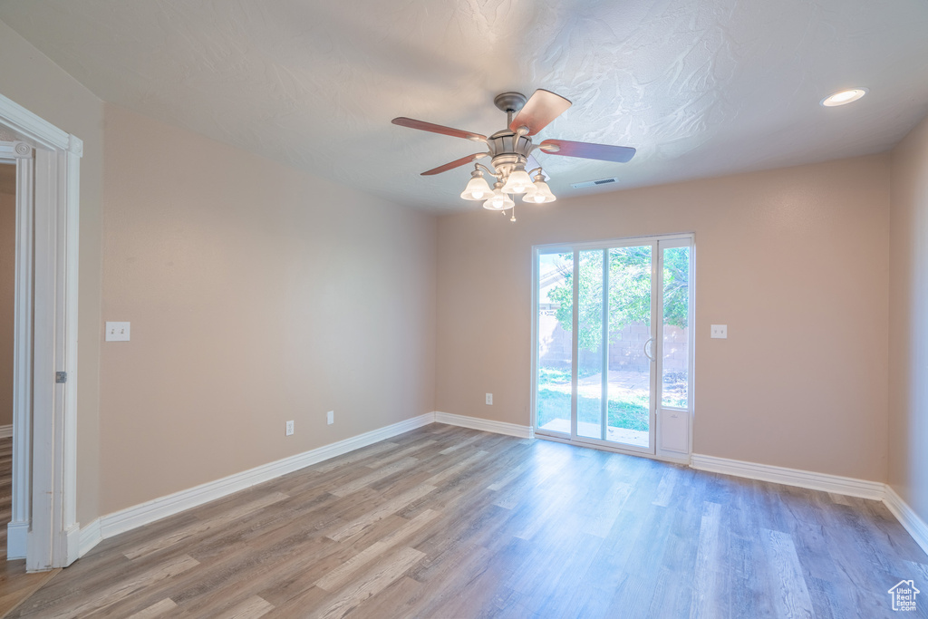 Empty room with light wood-type flooring and ceiling fan
