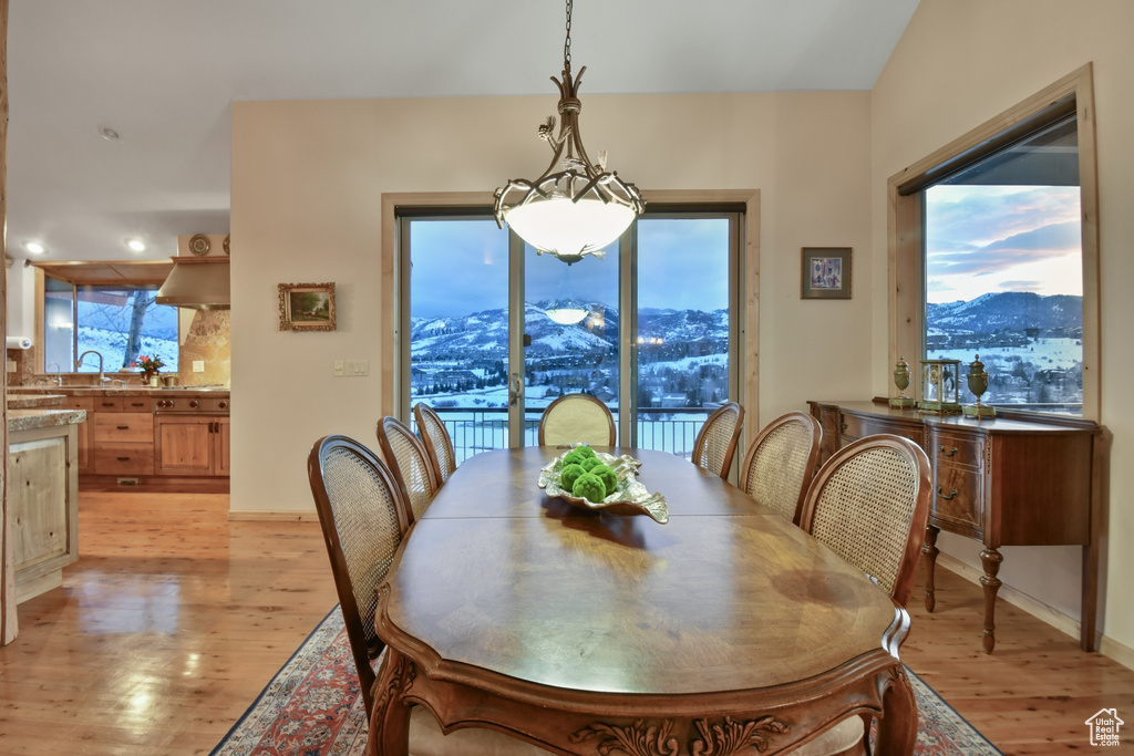 Dining room with a notable chandelier, a mountain view, and light hardwood / wood-style floors