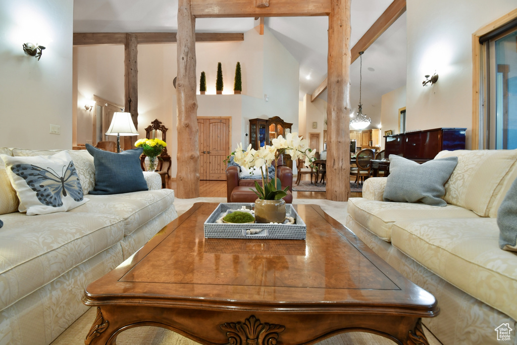Living room with high vaulted ceiling, hardwood / wood-style floors, and beamed ceiling