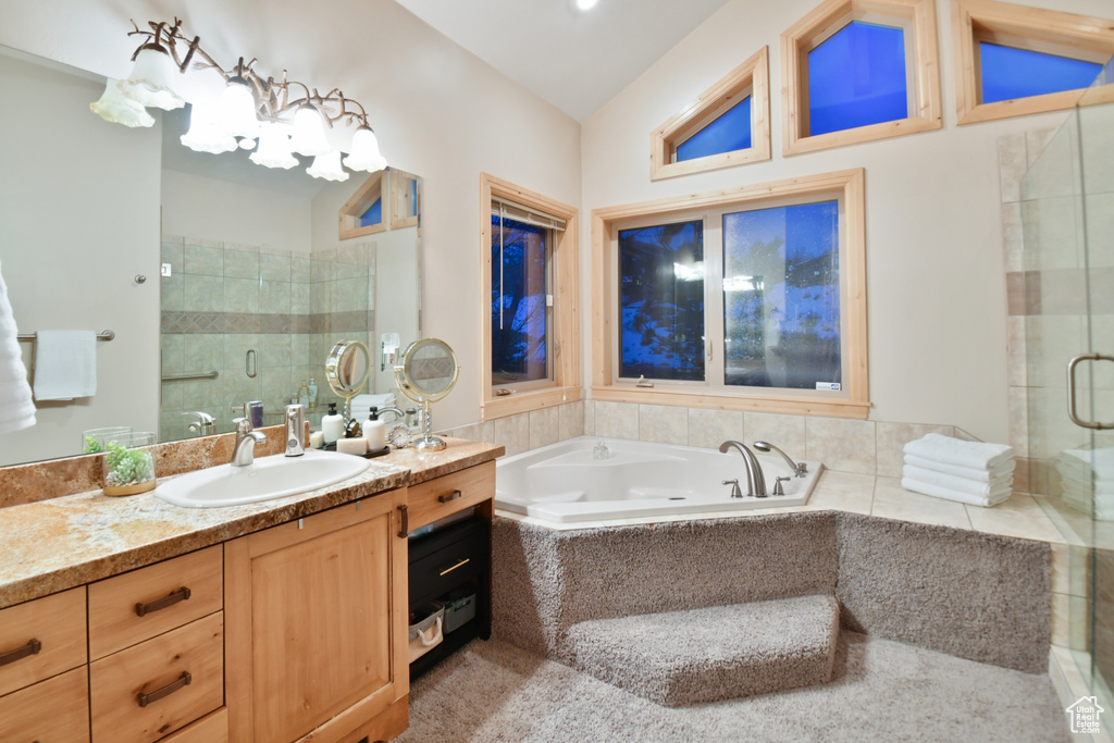 Bathroom with shower with separate bathtub, lofted ceiling, and oversized vanity
