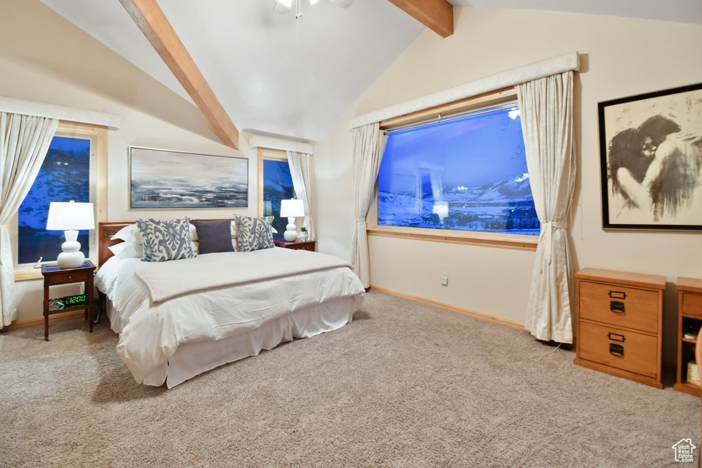Carpeted bedroom featuring ceiling fan and lofted ceiling with beams