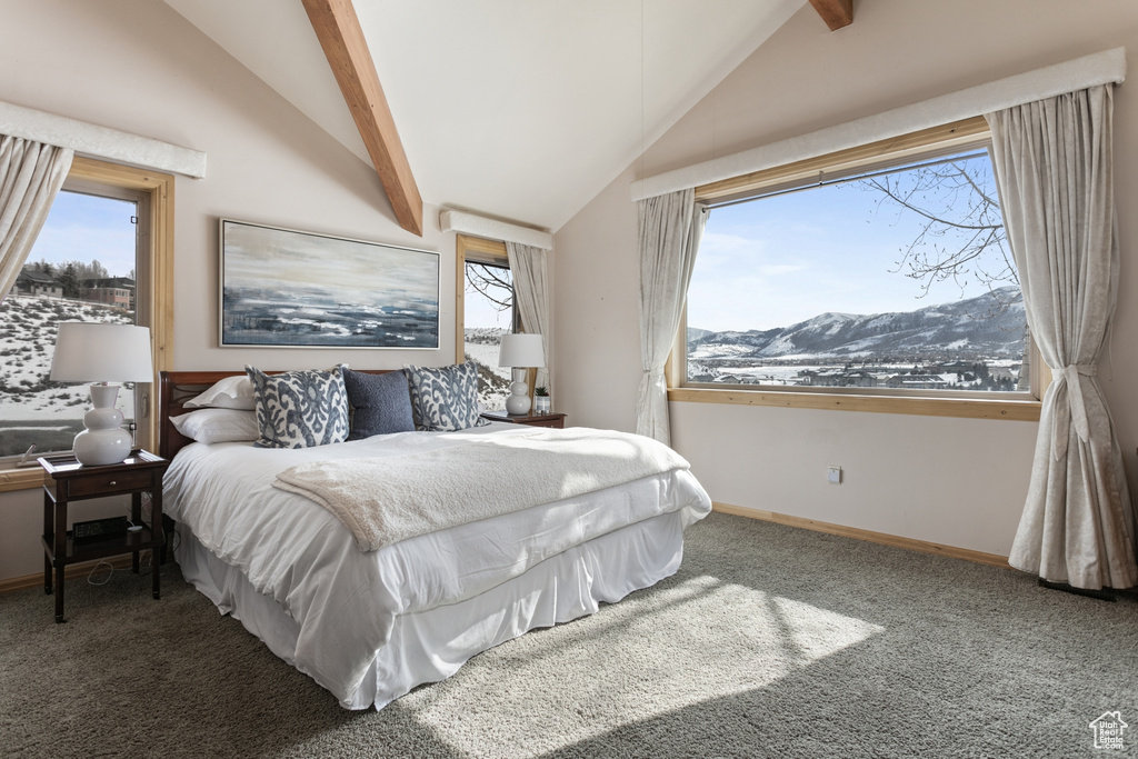 Bedroom featuring vaulted ceiling with beams, dark colored carpet, and a mountain view
