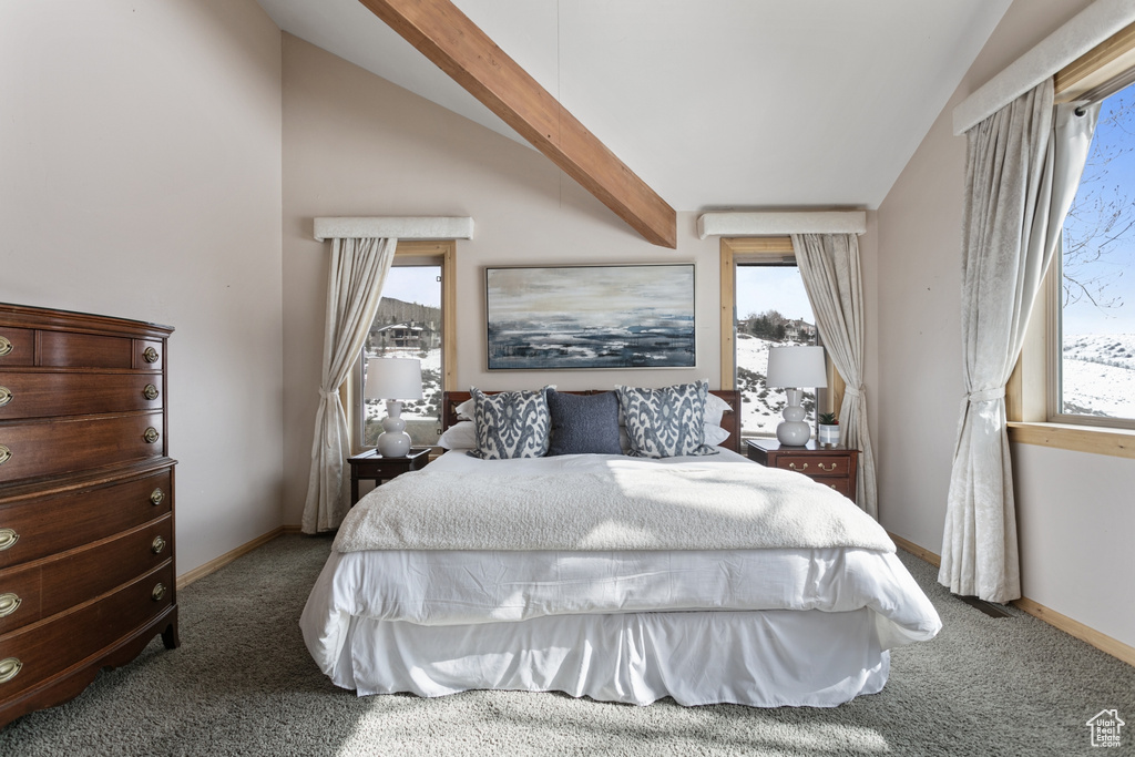 Carpeted bedroom featuring multiple windows and lofted ceiling with beams
