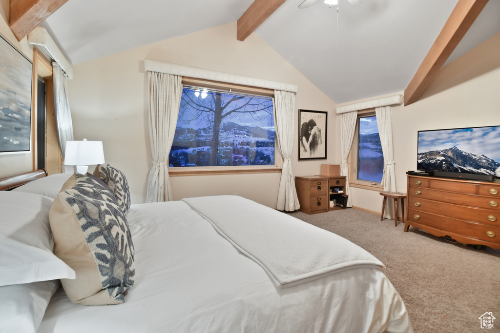 Carpeted bedroom featuring vaulted ceiling with beams and ceiling fan