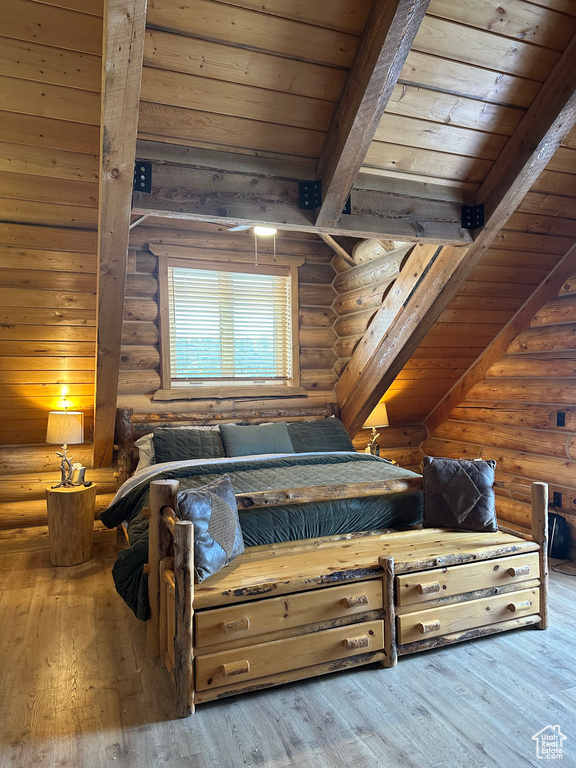 Bedroom with light hardwood / wood-style flooring, log walls, and wooden ceiling