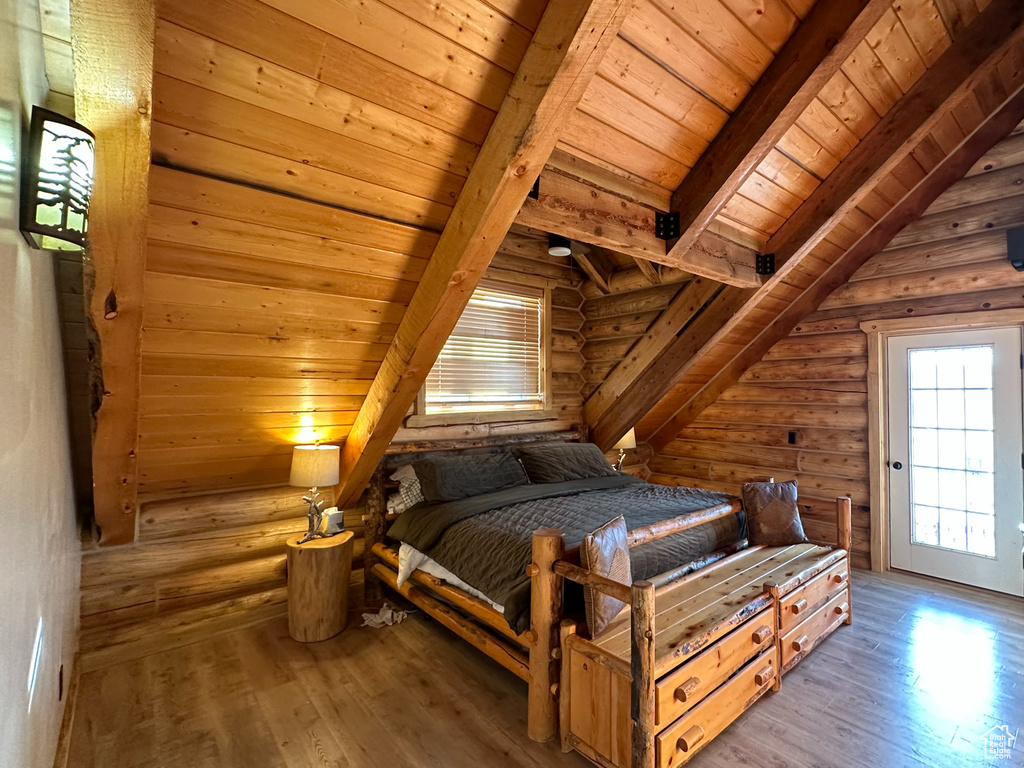 Bedroom with light hardwood / wood-style flooring, log walls, and wood ceiling
