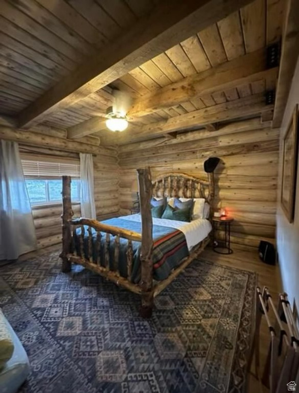 Bedroom featuring ceiling fan, log walls, wooden ceiling, and beamed ceiling