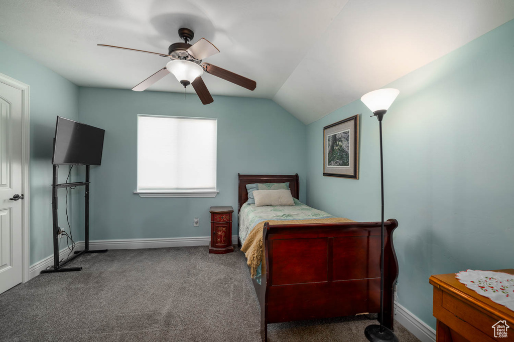 Bedroom featuring dark colored carpet, lofted ceiling, and ceiling fan