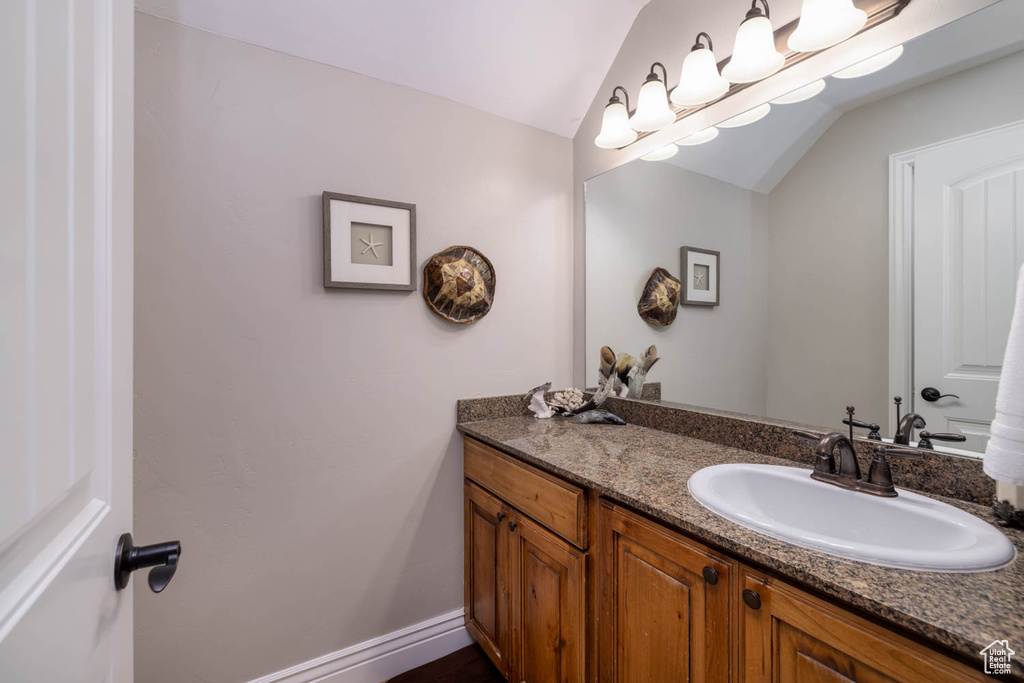 Bathroom featuring vaulted ceiling and vanity