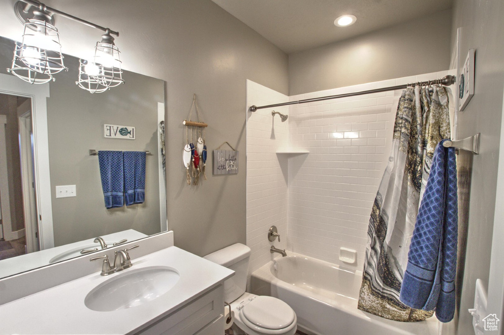 Full bathroom featuring shower / bathtub combination with curtain, vanity, toilet, and an inviting chandelier
