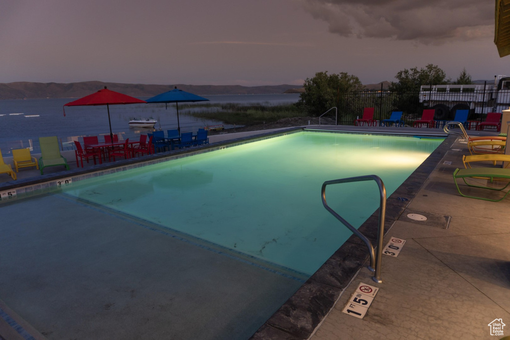 Pool at dusk featuring a patio area