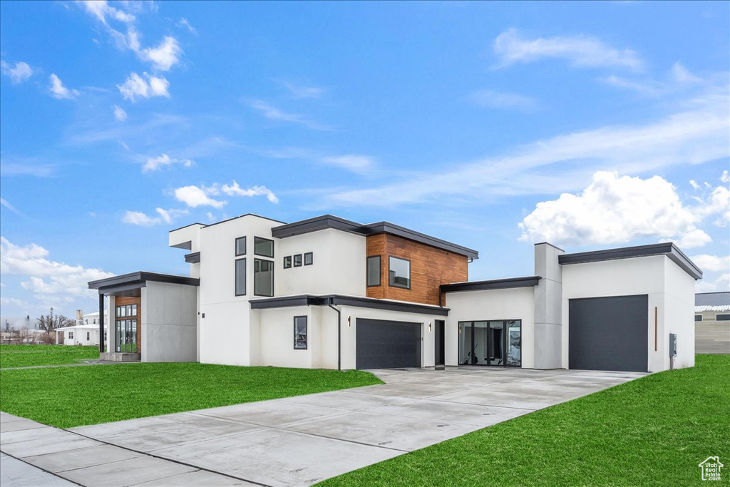 Contemporary house featuring a garage and a front lawn