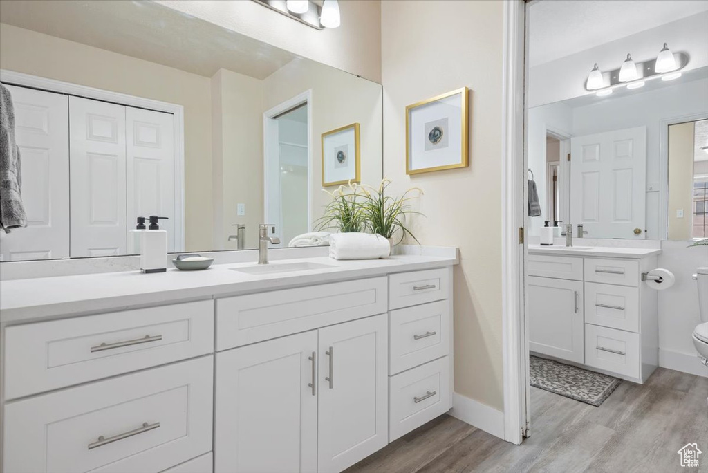 Bathroom featuring oversized vanity, hardwood / wood-style floors, and toilet