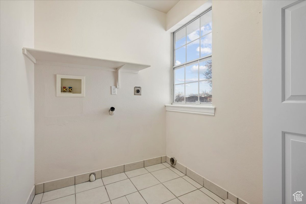 Washroom with light tile flooring, electric dryer hookup, and hookup for a washing machine