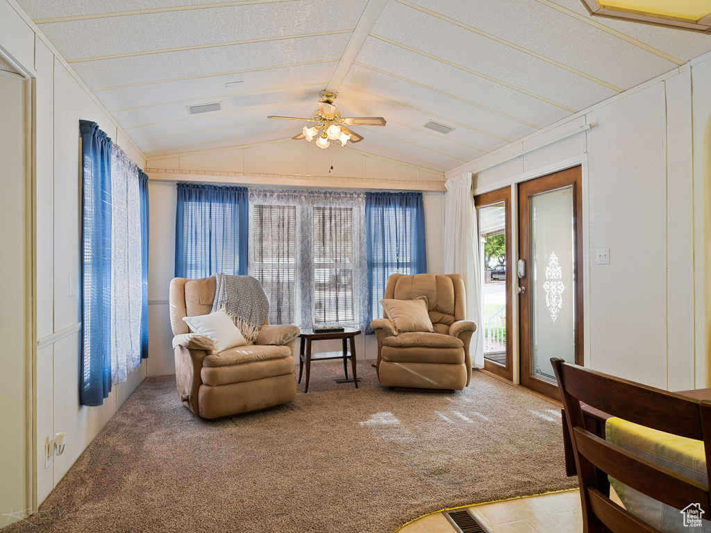 Carpeted living room featuring a textured ceiling, lofted ceiling, and ceiling fan