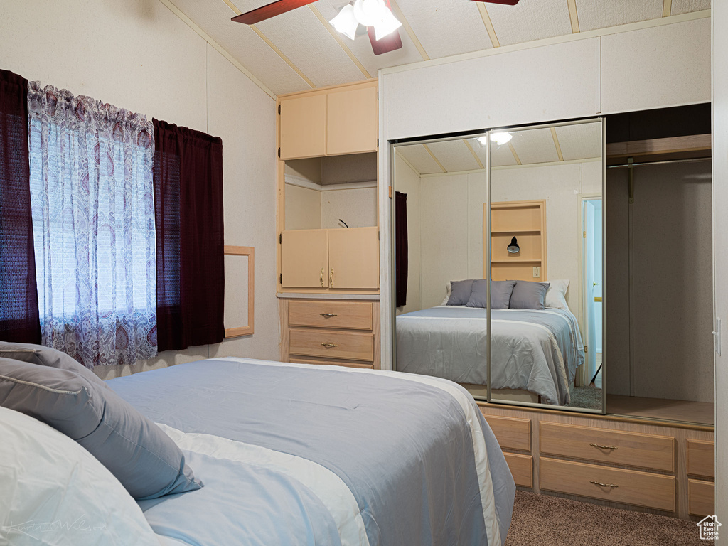 Carpeted bedroom with lofted ceiling, a closet, and ceiling fan