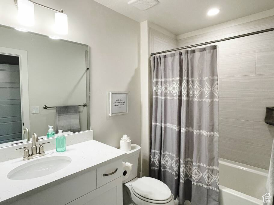 Full bathroom with shower / bath combo, toilet, and vanity