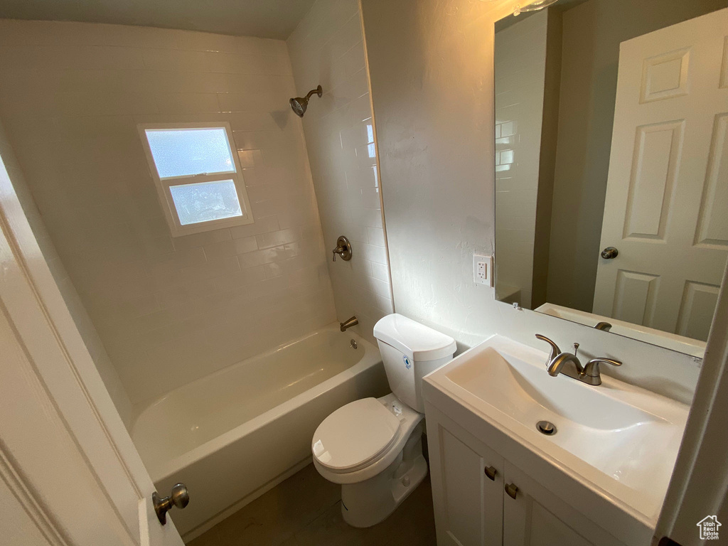 Full bathroom with oversized vanity, tiled shower / bath combo, and toilet