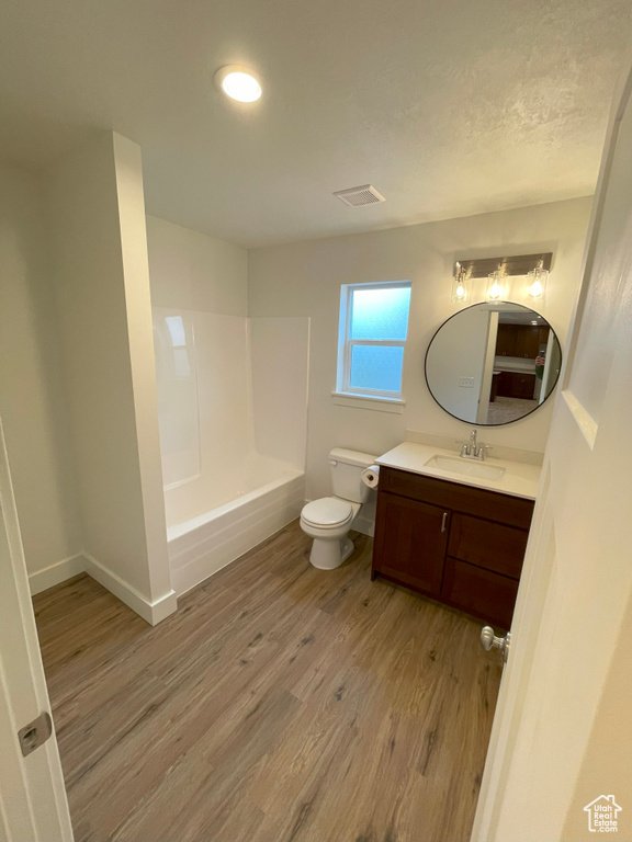 Full bathroom featuring vanity, hardwood / wood-style floors, toilet, and bathing tub / shower combination