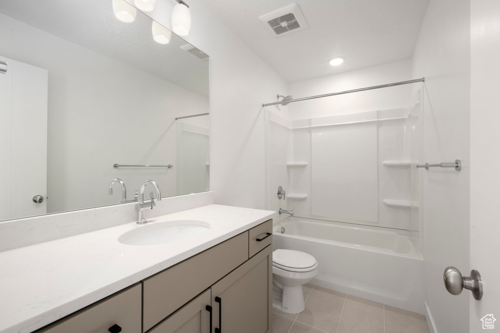 Full bathroom featuring tile floors, shower / bath combination, vanity, and toilet