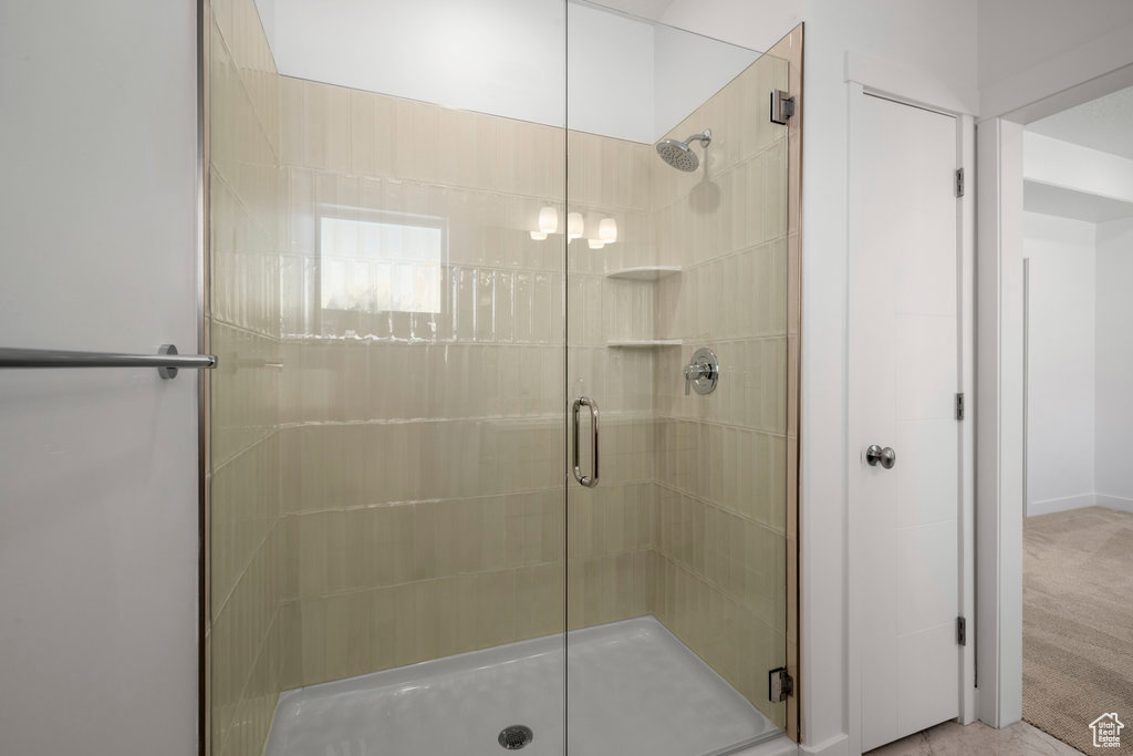 Bathroom with an enclosed shower and a notable chandelier