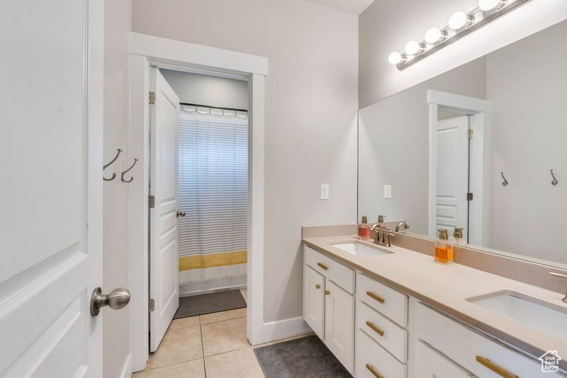 Bathroom featuring tile flooring and double vanity