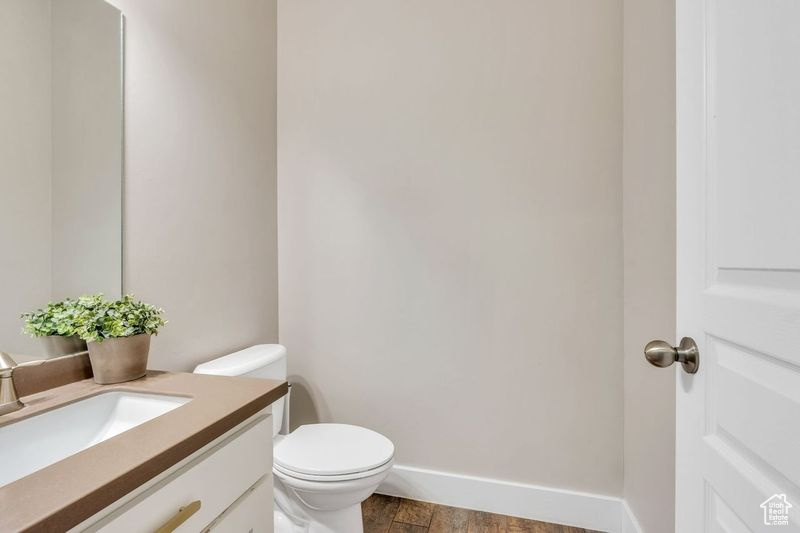 Bathroom with vanity, toilet, and hardwood / wood-style flooring