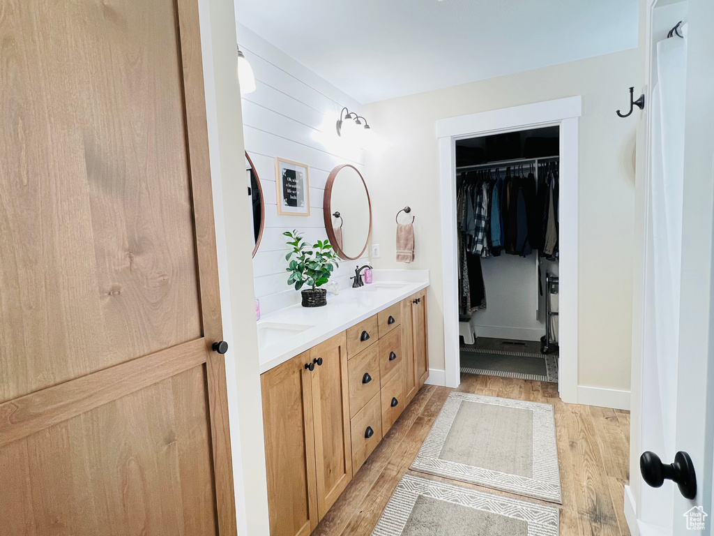 Bathroom with double vanity and hardwood / wood-style floors