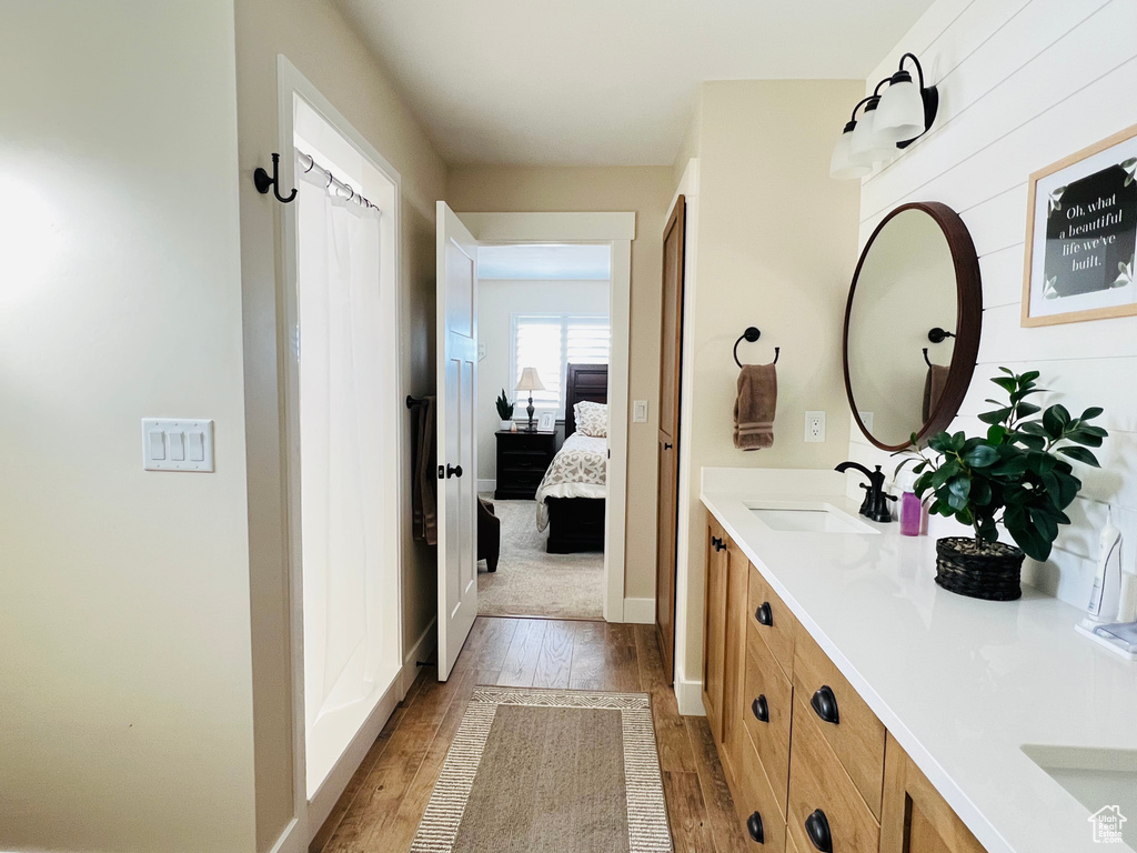 Bathroom featuring hardwood / wood-style flooring and dual bowl vanity