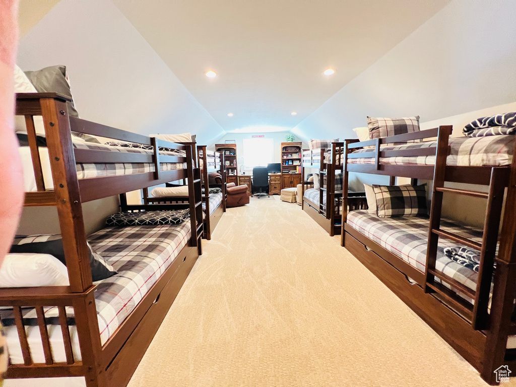 Bedroom featuring light colored carpet and lofted ceiling