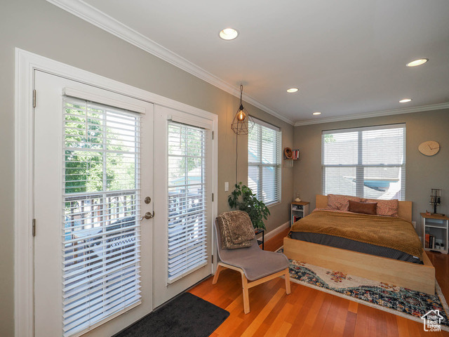 Bedroom with light wood-type flooring, ornamental molding, french doors, and access to outside