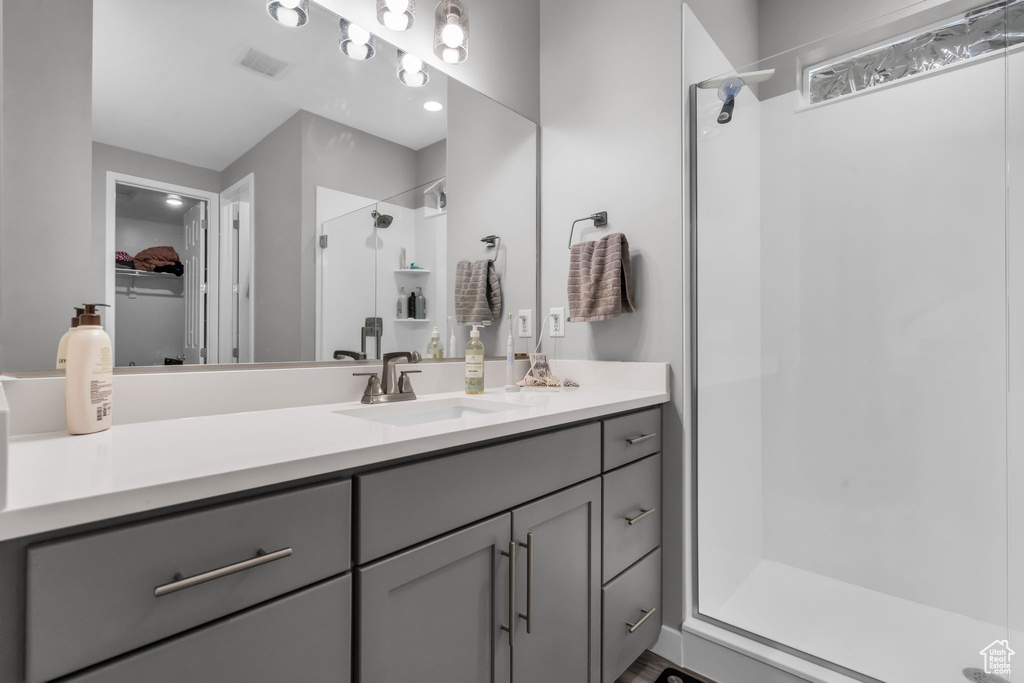 Bathroom with walk in shower and vanity with extensive cabinet space