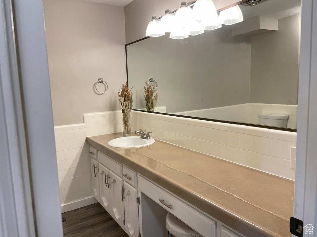 Bathroom featuring backsplash, hardwood / wood-style floors, and vanity