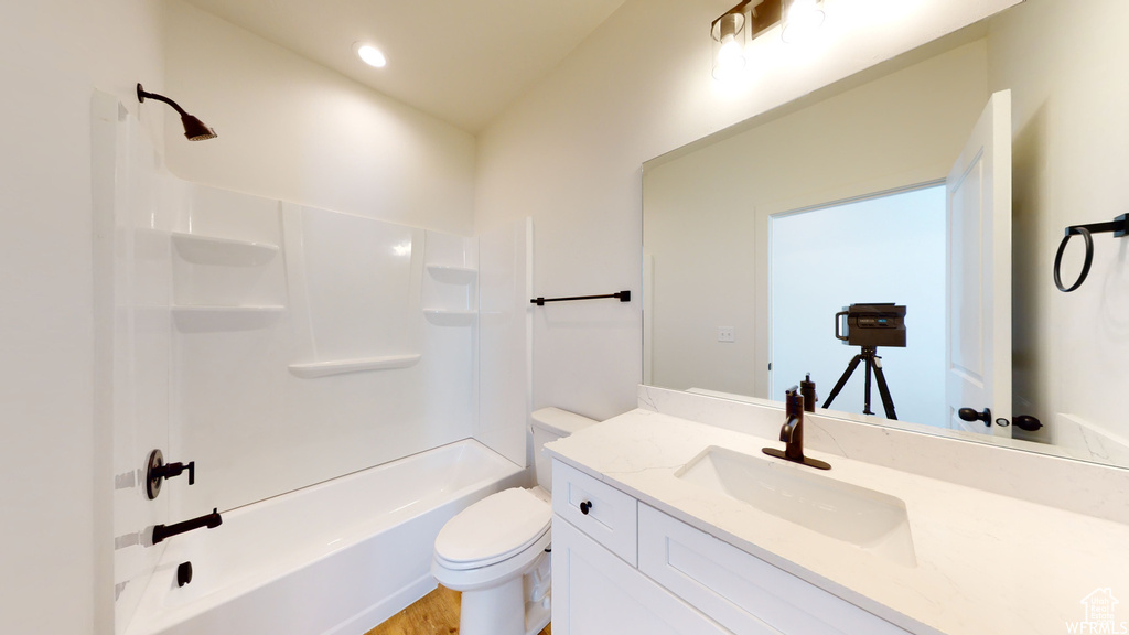 Full bathroom featuring vanity, hardwood / wood-style flooring, toilet, and tub / shower combination