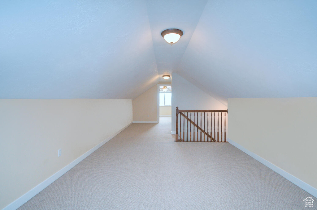 Bonus room featuring vaulted ceiling and light carpet