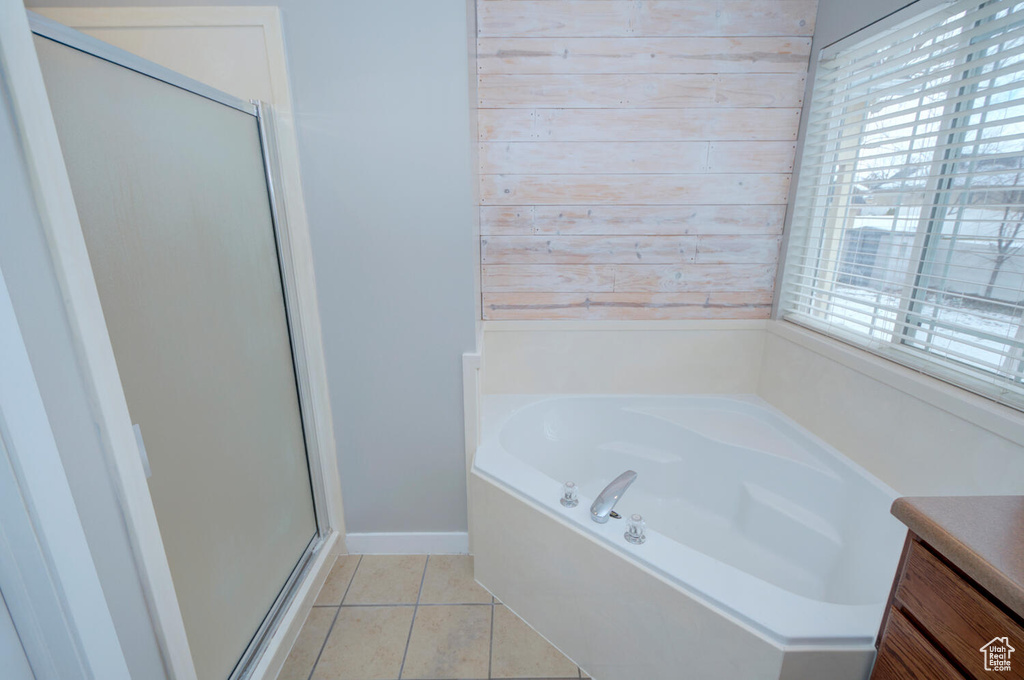 Bathroom with a wealth of natural light, vanity, separate shower and tub, and tile floors