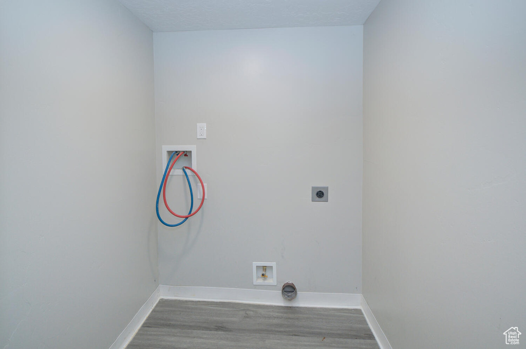 Washroom with hookup for an electric dryer, dark hardwood / wood-style floors, and washer hookup