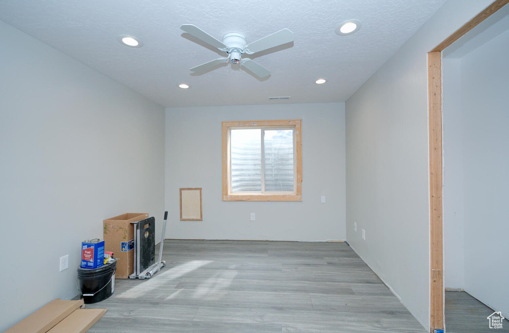 Empty room with light hardwood / wood-style flooring, a textured ceiling, and ceiling fan