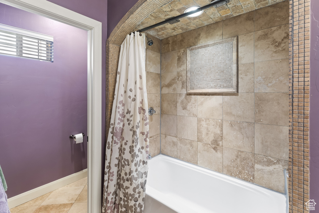 Bathroom with shower / tub combo with curtain and tile flooring