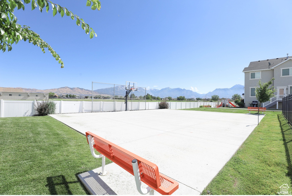 View of property's community featuring a mountain view, a lawn, and basketball court
