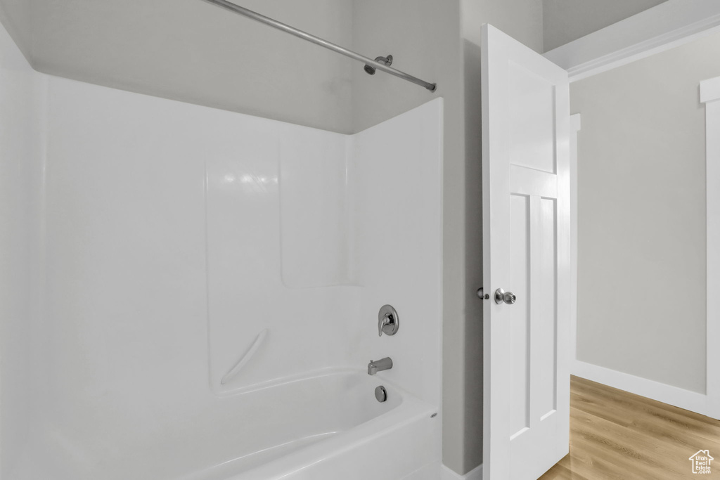 Bathroom featuring hardwood / wood-style flooring and bathing tub / shower combination