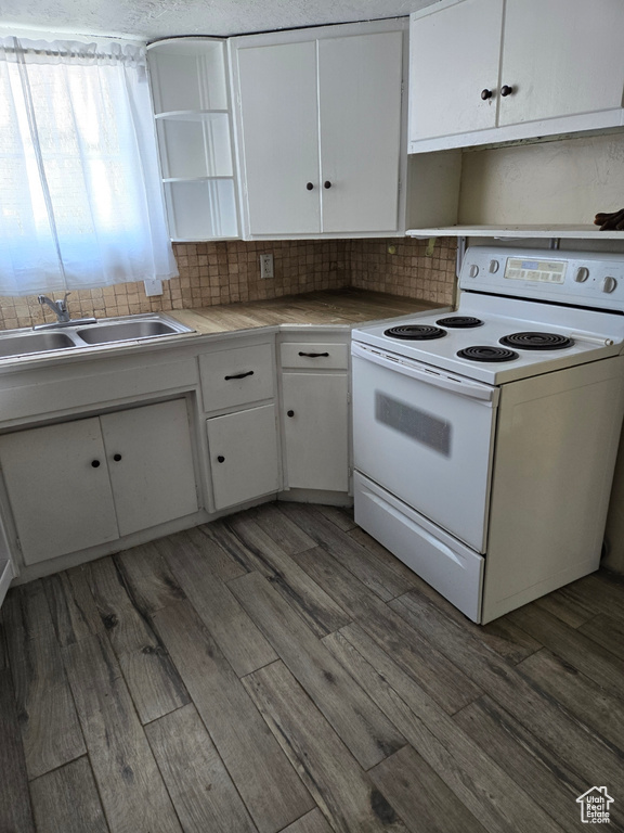 Kitchen featuring white cabinetry, sink, electric stove, tasteful backsplash, and dark hardwood / wood-style flooring