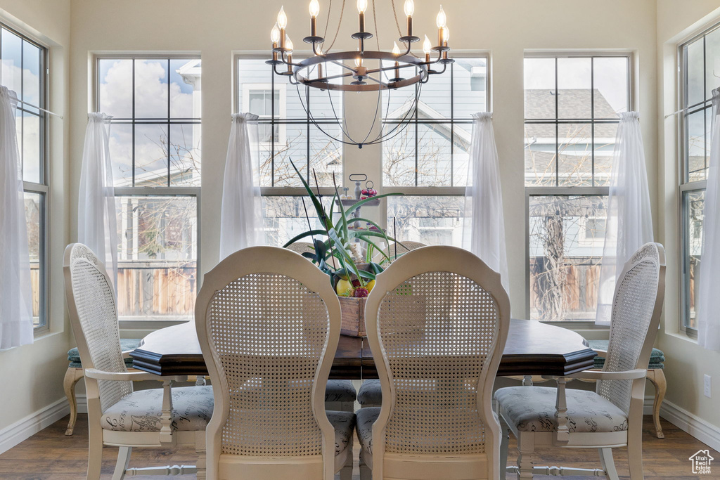 Dining area featuring a healthy amount of sunlight, a chandelier, and hardwood / wood-style flooring